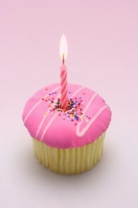 Pink cupcake with one lit candle