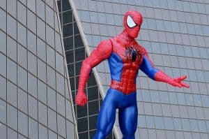 Spider-Man action figure by a building with glass windows