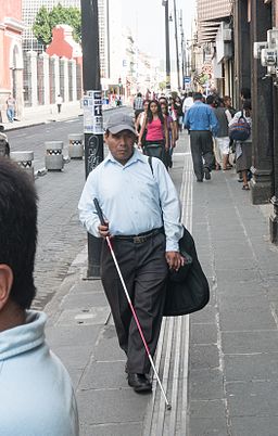 blind man walking with a long cane