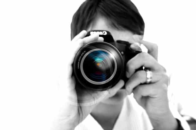 photographer holding SLR camera, black and white