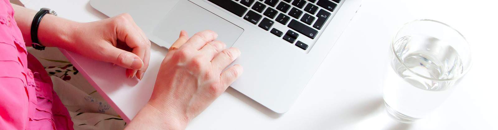hands on the touchpad of a Macbook Air
